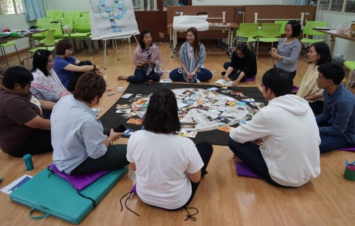 A KITA Learn workshop: participants sitting in a circle around a shared visual exercise
